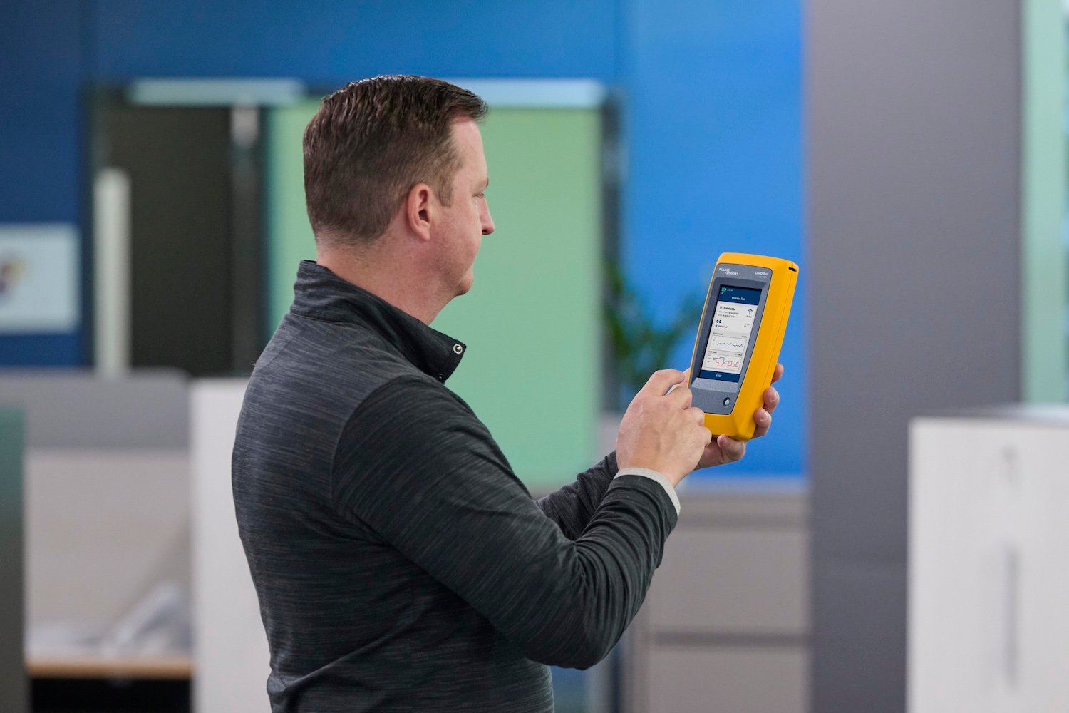 Technician using a LinkIQ Duo to analyze the Wi-Fi environment.