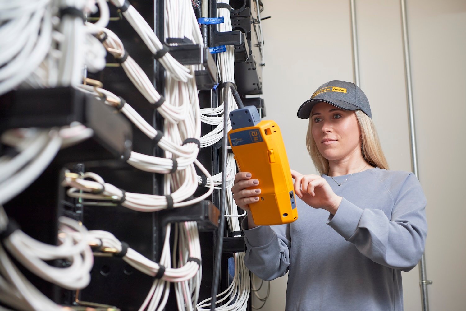 Man testing network cabling in a small room