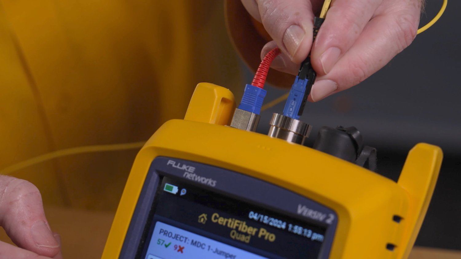 Plugging an MDC link into the top of a yellow CertiFiber Pro device.
